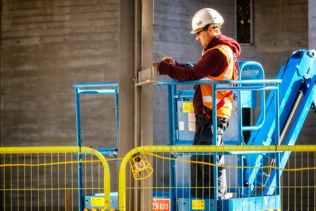 Electrician installing wiring on a commercial site